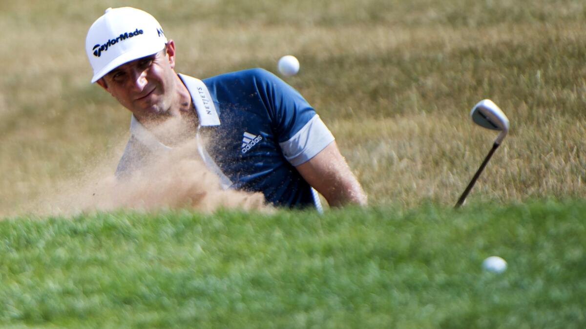 Dustin Johnson blasts out of a bunker on the ninth hole Thursday during the first round of the Canadian Open.