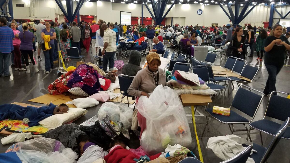 A woman sorts through clothing donated for those who have taken shelter at the George R. Brown Convention Center in Houston because of Hurricane Harvey. (Molly Hennessy-Fiske / Los Angeles Times)