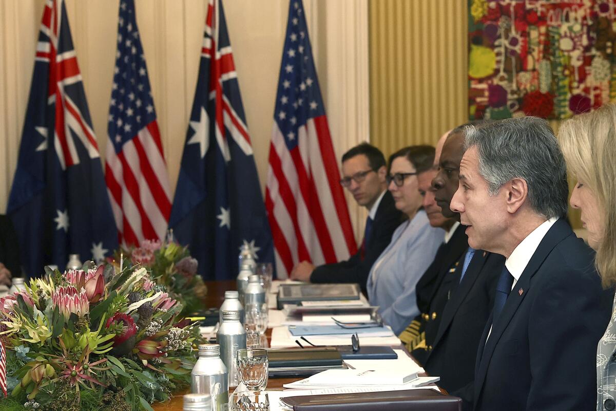 Secretary of State Antony Blinken sits at a table with other diplomats