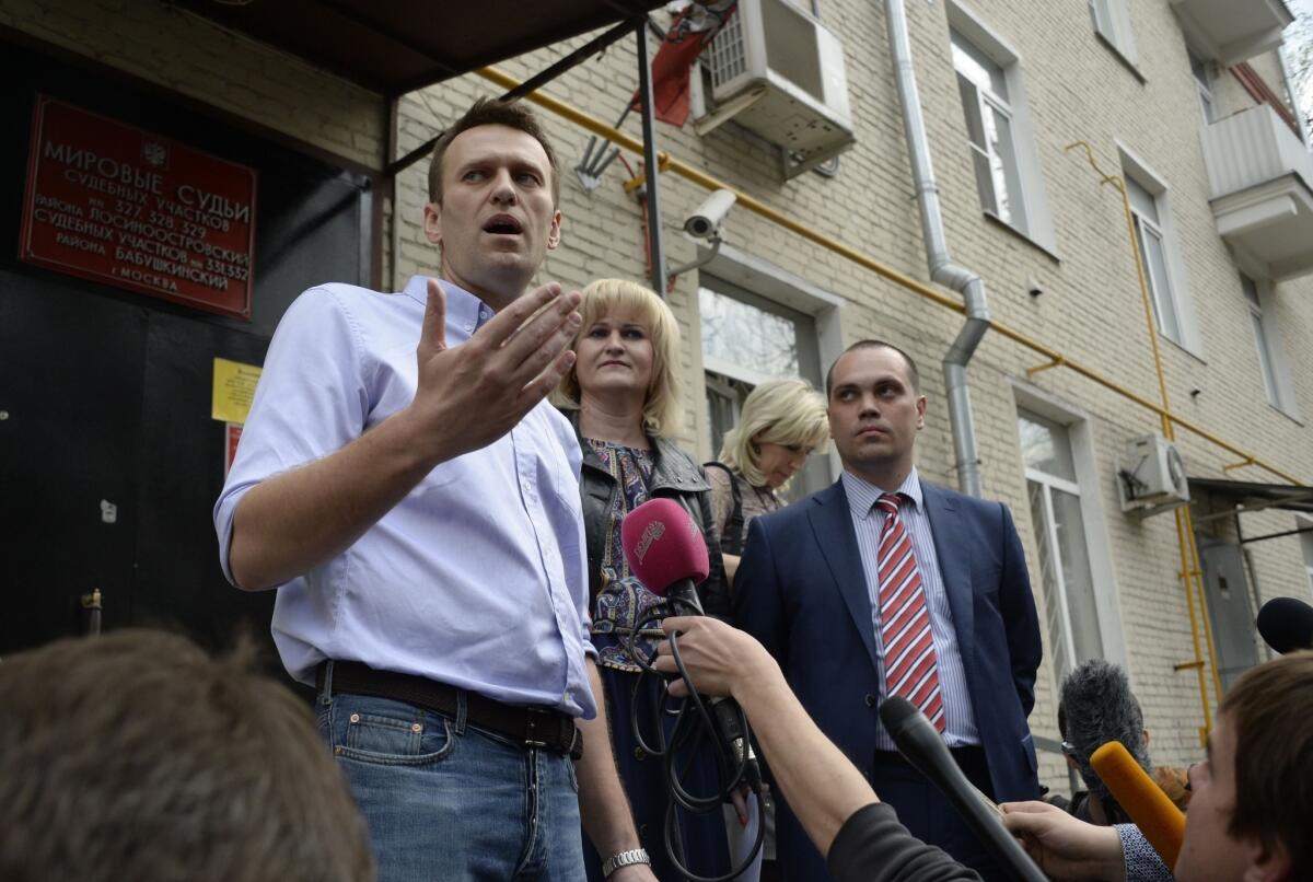 Kremlin critic and opposition leader Alexei Navalny speaks with journalists outside a courthouse in Moscow on Tuesday after his conviction on slander charges. Navalny, under house arrest for the last two months, had a previous five-year sentence tied to his anti-corruption crusading suspended last year on condition he not run afoul of the law. He is likely to be returned to prison soon.