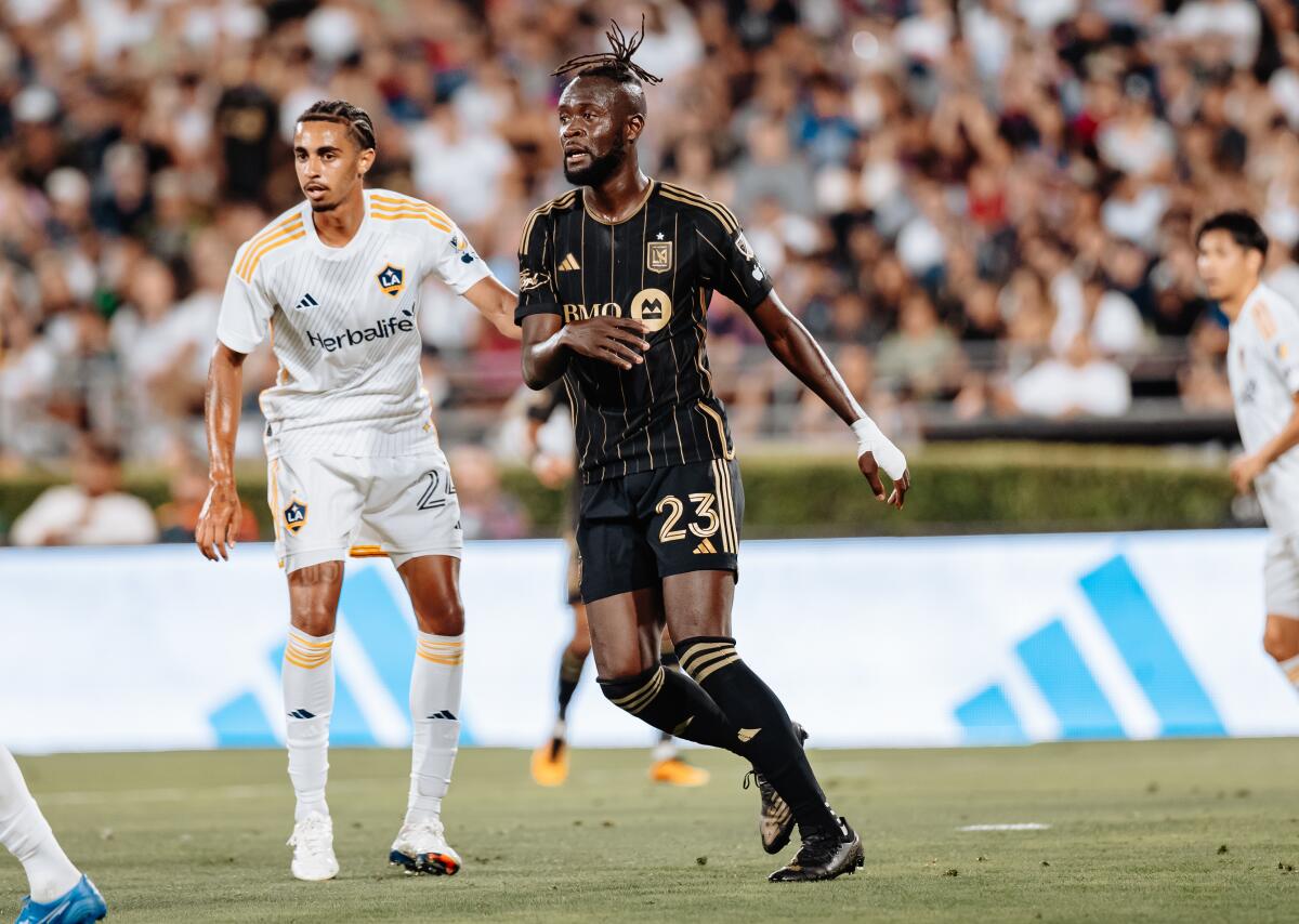Galaxy defender Jalen Neal touches LAFC striker Kei Kamara while they jostle for position on the pitch during a match. 