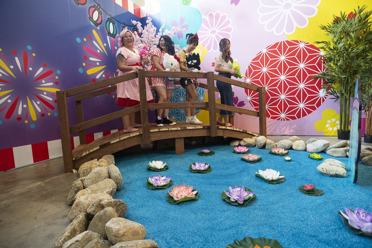 Visitors stand on a bridge in the Tokyo room of the Hello Kitty Friends Around the World Tour pop-up.