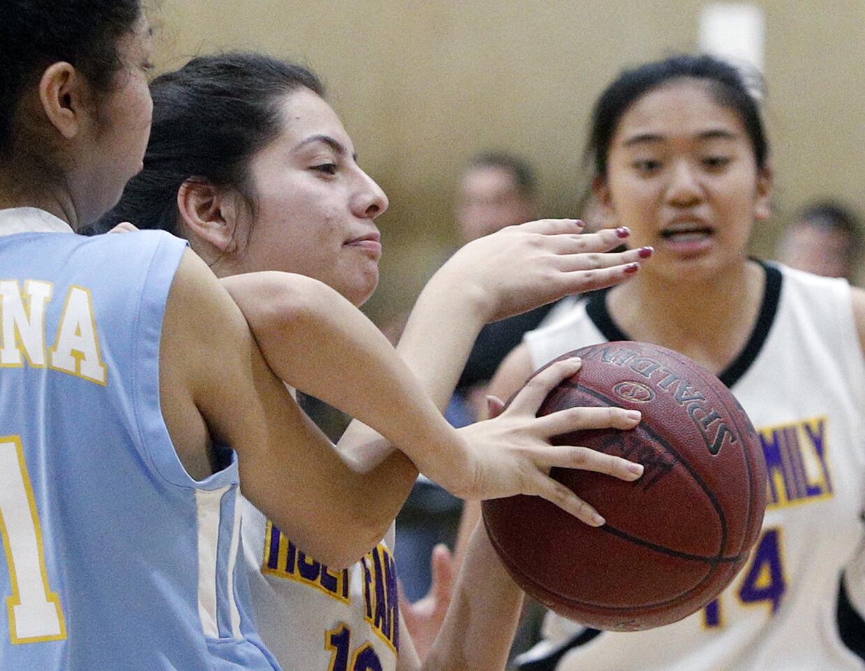 Holy Family's Ashley Margarito and Ramona Convent's Calista Rugama tangle their arms together battling for a rebound in a Horizon League girls' basketball game at the Pacific Community Center & Park in Glendale on Thursday, January 10, 2019.