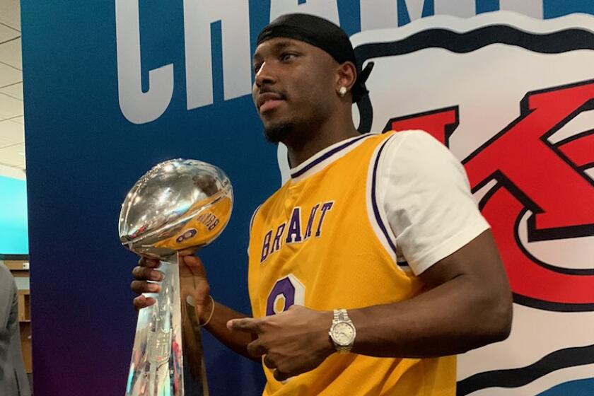 Kansas Chiefs running back LeSean McCoy wears a Kobe Bryant jersey while holding the Vince Lombardi trophy following the team's Super Bowl LIV win over the 49ers on Sunday.