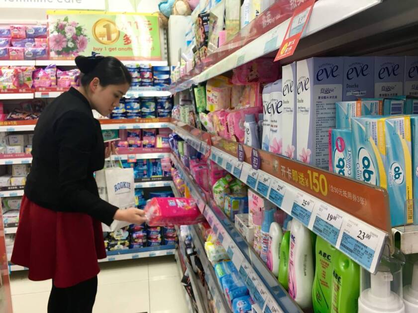 A Chinese woman looks for sanitary pads in a store in central Beijing, where tampons occupy a small corner on the shelf of feminie hygiene products.