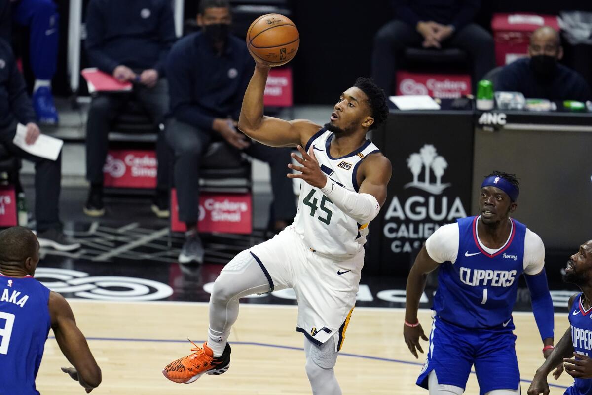 Utah Jazz guard Donovan Mitchell (45) shoots past Los Angeles Clippers guard Reggie Jackson (1) during the first half of an NBA basketball game Wednesday, Feb. 17, 2021, in Los Angeles. (AP Photo/Marcio Jose Sanchez)