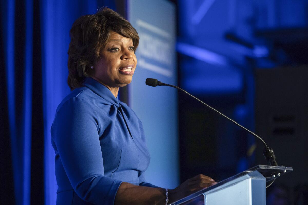 Woman speaking into a microphone at a lectern 