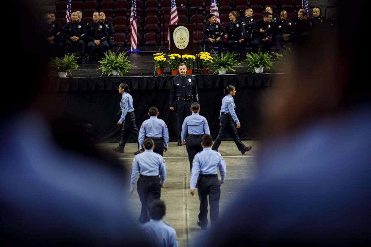 Cadets file past Los Angeles Police Chief Charlie Beck for inspection before their graduation ceremony at USC's Galen Center in June.