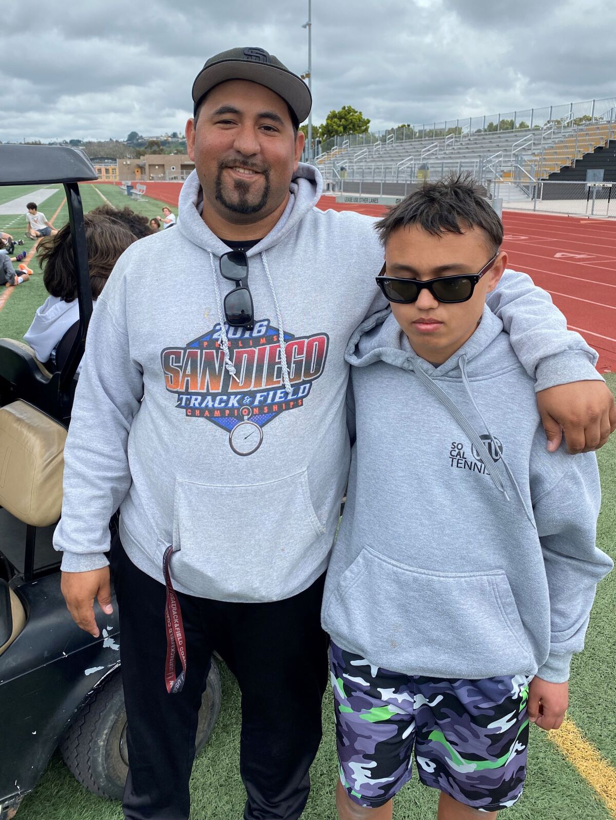 Mission Bay High School Track coach Danny Perez with freshman Chris Adamson who runs the 100-meter and 200-meter races.