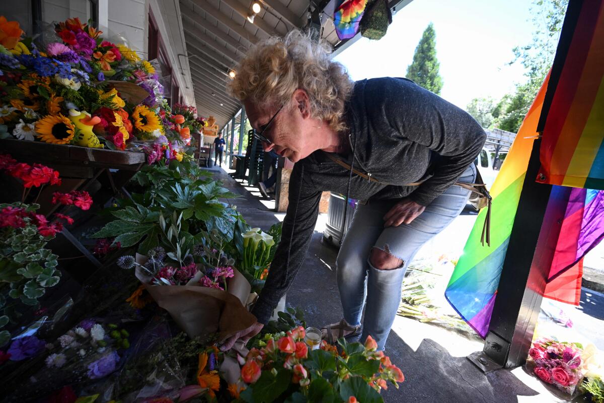 A resident leaves flowers at a makeshift memorial outside the Mag.Pi 