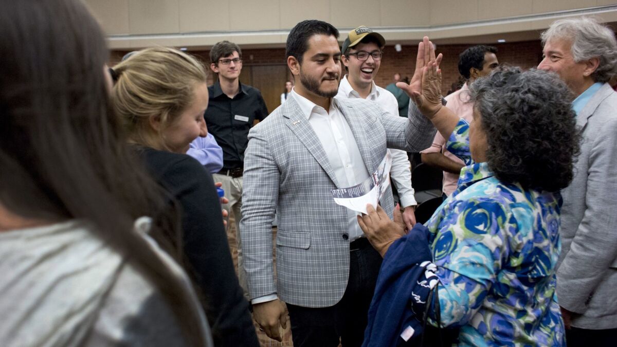 Democrat Abdul El-Sayed gives a high-five after a town hall event at Hope College in Holland, Mich. If elected, El-Sayed would become the nation's first Muslim governor.