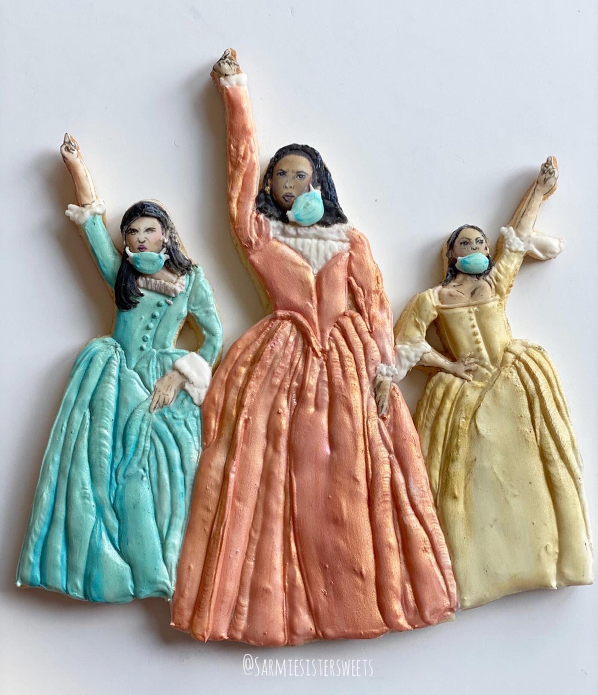 Cookies shaped like the Schuyler sisters, from the musical "Hamilton," in masks
