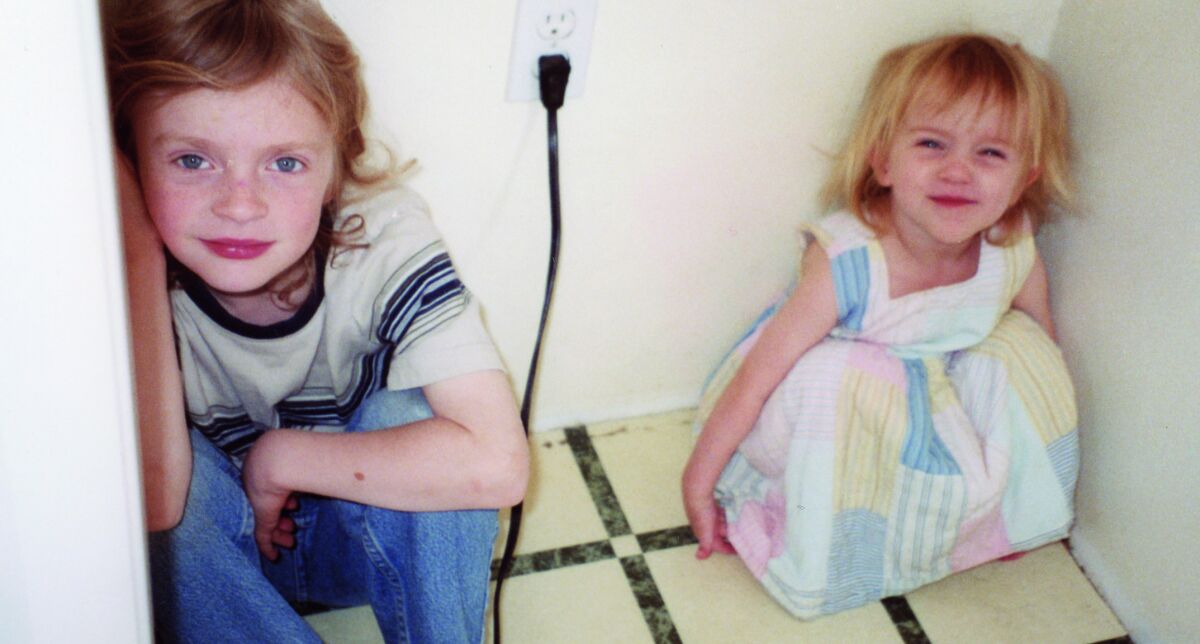 Two children sit on the floor