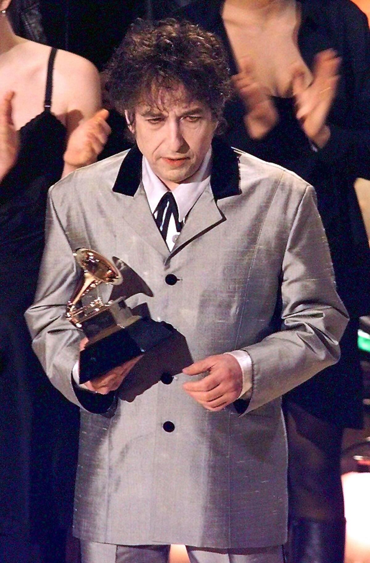 Bob Dylan, receiving the 1998 Grammy Award for album of the year for "Time Out of Mind." He didn't win his first Grammy until 1973.