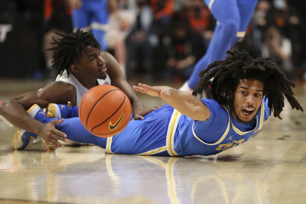UCLA guard Tyger Campbell, right, and Oregon State forward Glenn Taylor Jr. scramble for the ball during the second half.