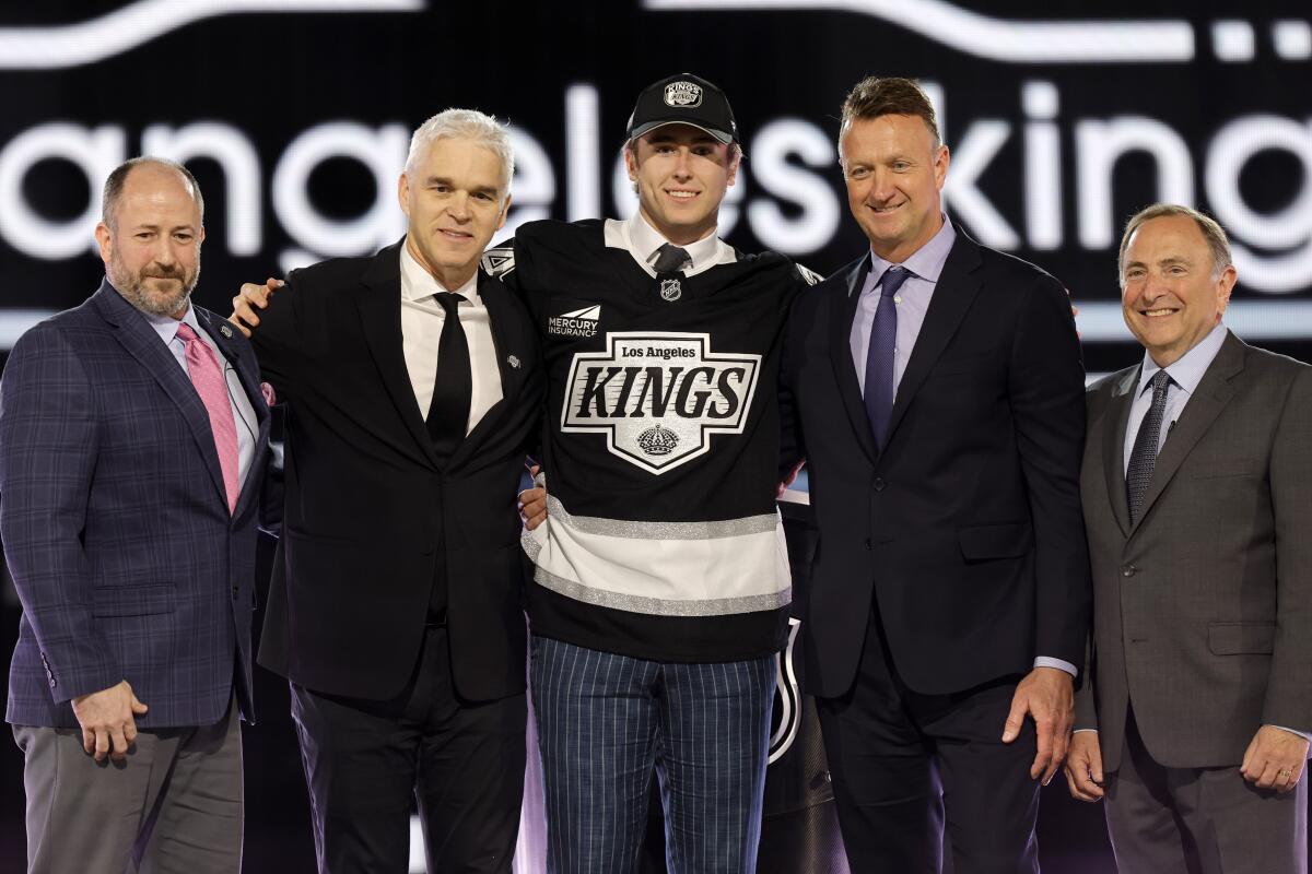 Liam Greentree, center, poses between Kings president Luc Robitaille, left, and general manager Rob Blake.