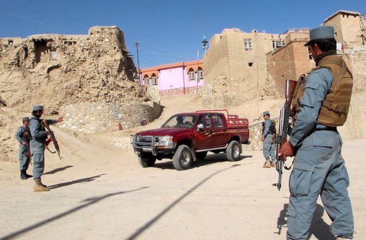 Afghan policemen check a vehicle on a roadside in Ghazni province, Afghanistan, on Thursday.