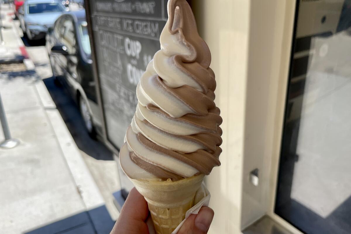 Chocolate and vanilla soft serve twirl in a cone at a food truck.