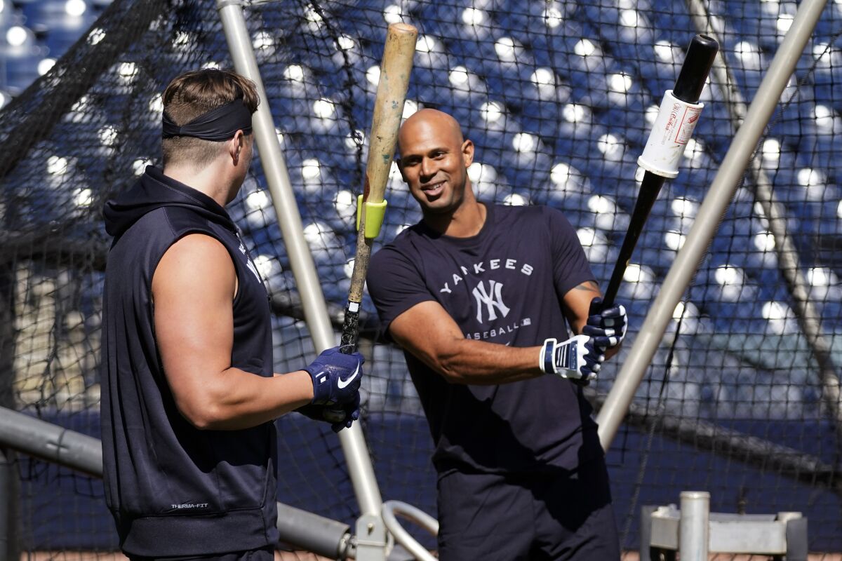 New York Yankees infielder Luke Voit, left, and outfielder Aaron Hicks talk outside the batting cage during a spring training baseball workout, Sunday, March 13, 2022, in Tampa, Fla. (AP Photo/John Raoux)