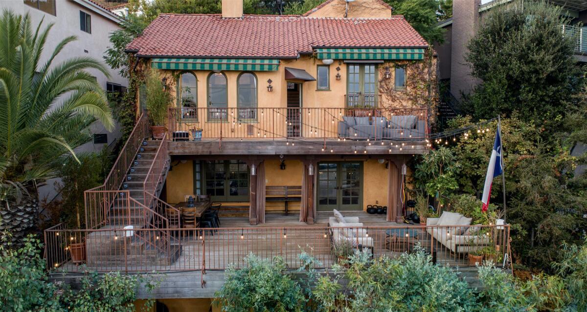 Built in 1925, the hillside home includes two decks, a loggia and a tropical backyard with a bridge, koi pond and fire pit.