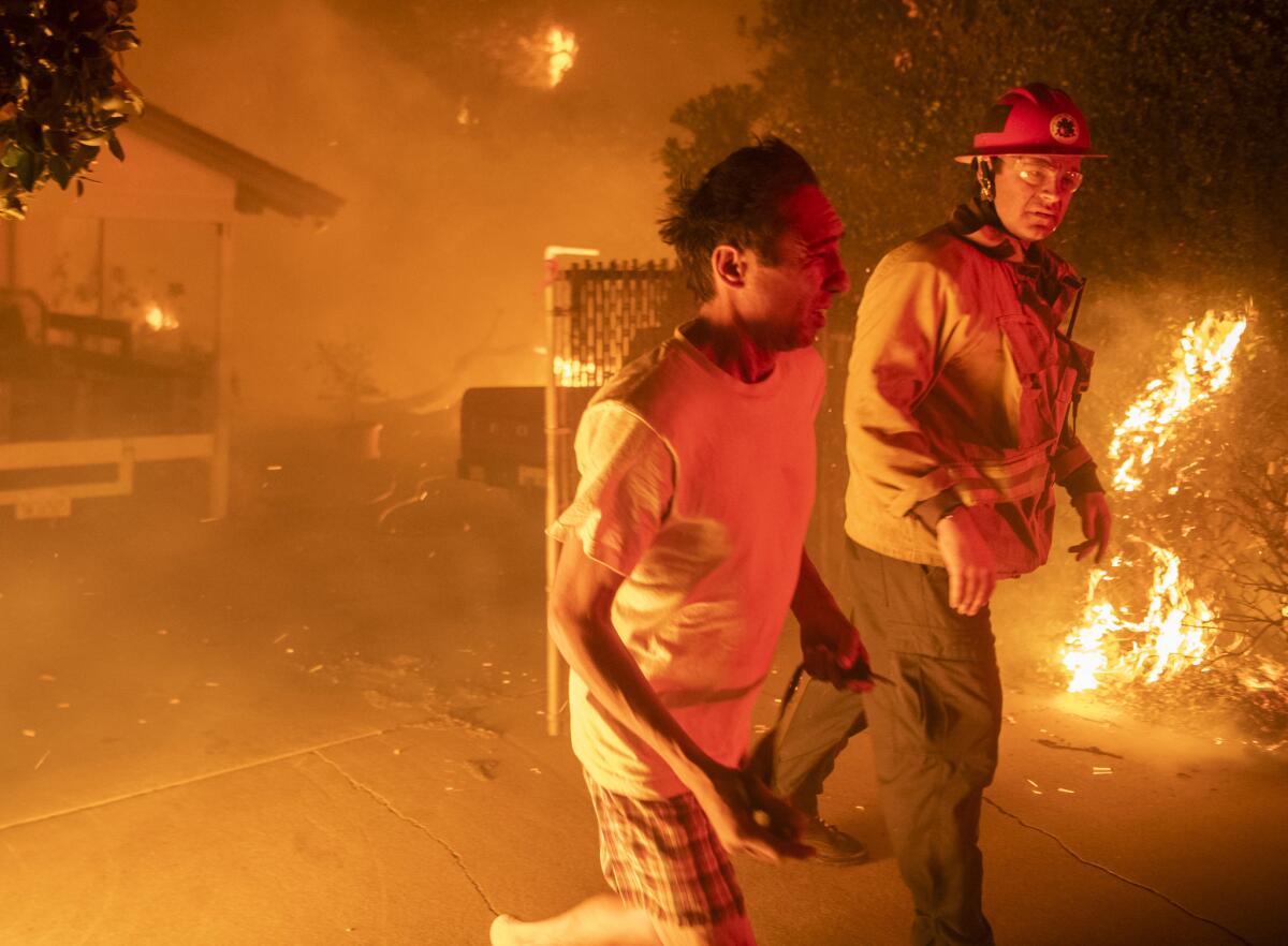 A resident evacuates his home on Quinta Vista Drive and East Hillcrest Road in Thousand Oaks early Friday morning. Residents were awoken in the middle of the night by mandatory evacuations from the Woolsey Fire.