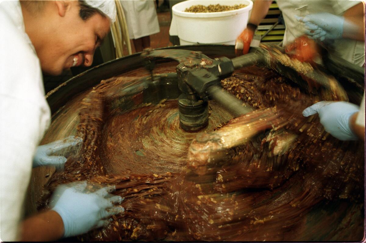 FO.See*s#1.IS.12/17.Nuts are added to fudge as it is being mashed in huge mixer at See's Candy Factory on La Cienega. 