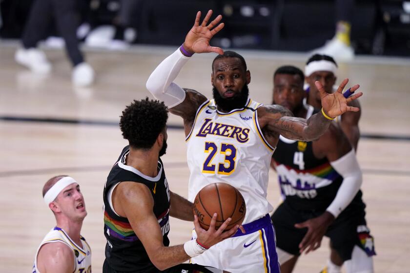 Los Angeles Lakers' LeBron James (23) and Alex Caruso, left, defend as Denver Nuggets guard Jamal Murray, second from left, attempts to pass the ball during the second half of Game 3 of the NBA basketball Western Conference final Tuesday, Sept. 22, 2020, in Lake Buena Vista, Fla. (AP Photo/Mark J. Terrill)