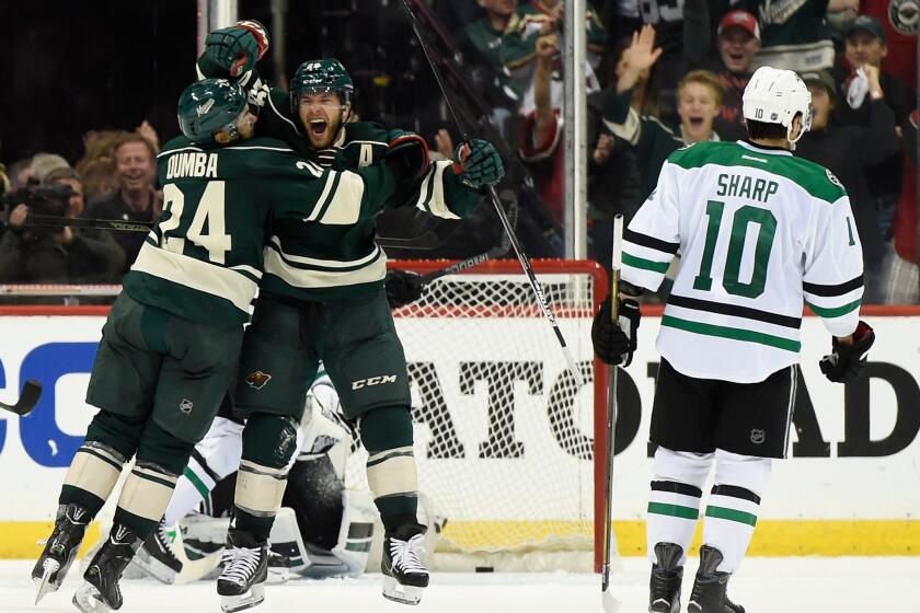 Wild defenseman Matt Dumba (24) celebrates with forward Jason Pominville (29) after Pominville scores in the second period against Patrick Sharp (10) and the Dallas Stars.