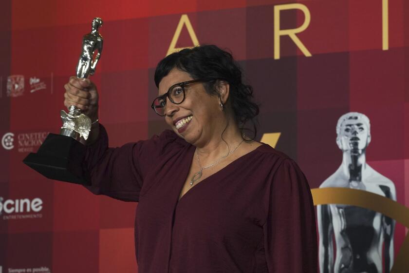 Tatiana Huezo con el premio a mejor película por "Noche de fuego" en la 64a entrega del Premio Ariel del Cine Mexicano en la Ciudad de México el 11 de octubre de 2022. (Foto AP/Marco Ugarte)