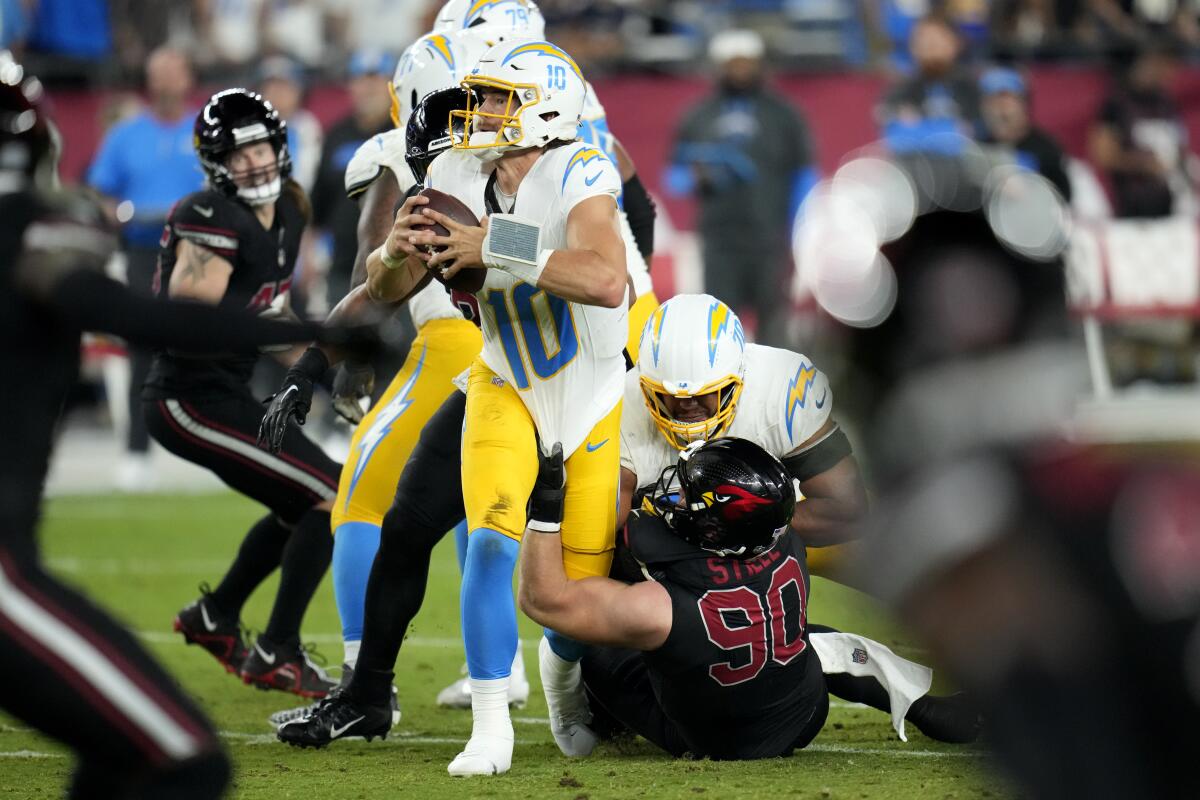 Chargers quarterback Justin Herbert is sacked by Arizona Cardinals defensive end Ben Stille in the first half.