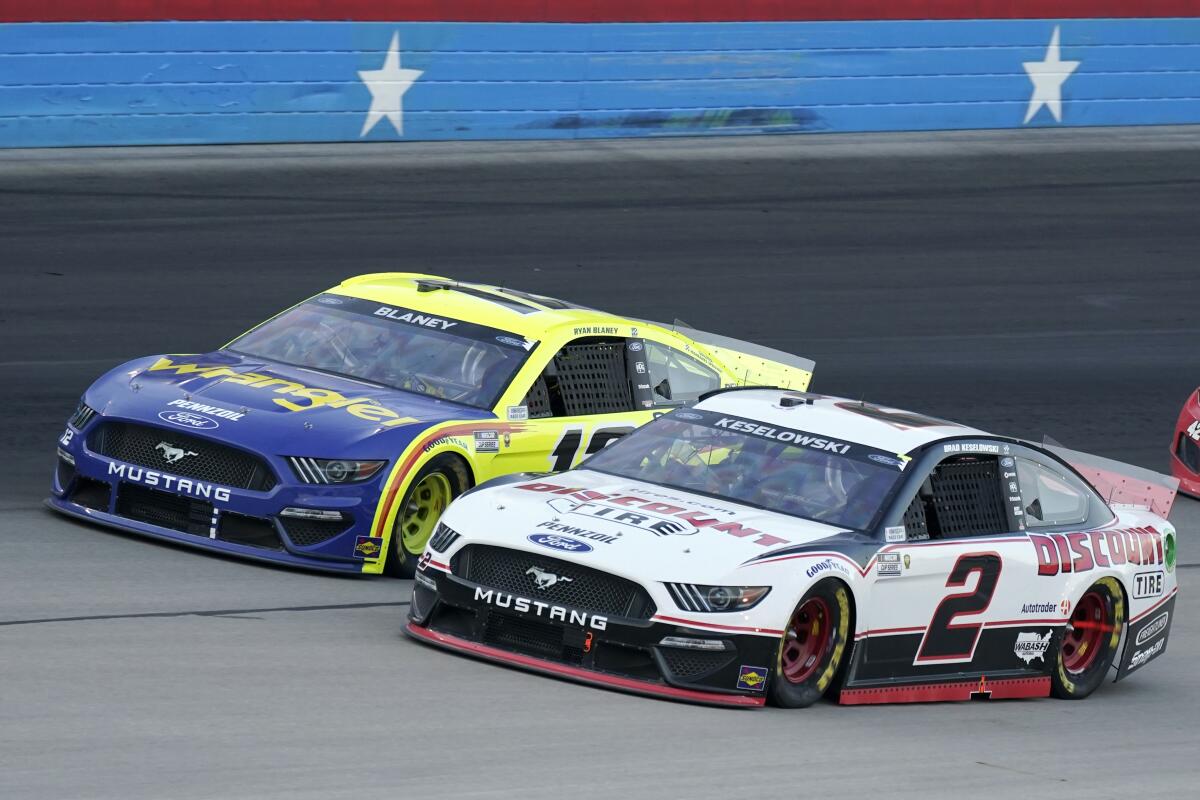 Brad Keselowski (2) and Ryan Blaney, rear, come out of turn four competing for position during the NASCAR Cup Series All-Star auto race at Texas Motor Speedway in Fort Worth, Texas, Sunday, June 13, 2021. (AP Photo/Tony Gutierrez)
