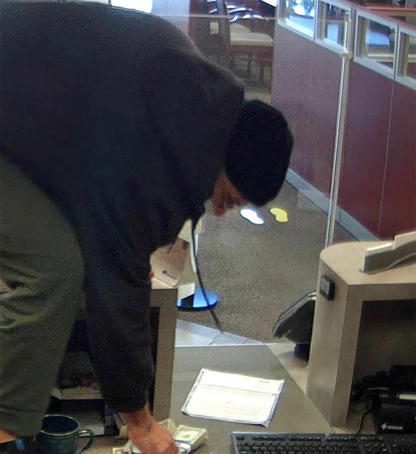 In this image taken from bank surveillance video and released by the City of Clearwater - Public Safety, David Marc Ratcliff robs a Wells Fargo bank on Tuesday, Nov. 30, 2021, in Clearwater, Fla. The serial Florida bank robber once dubbed the “I-4 bandit” was arrested Tuesday for the new holdup just months after his release from prison, police said. Ratcliff was caught after a brief chase in the Gulf Coast town of Belleair Beach following the bank robbery, authorities said. (City of Clearwater - Public Safety via AP)