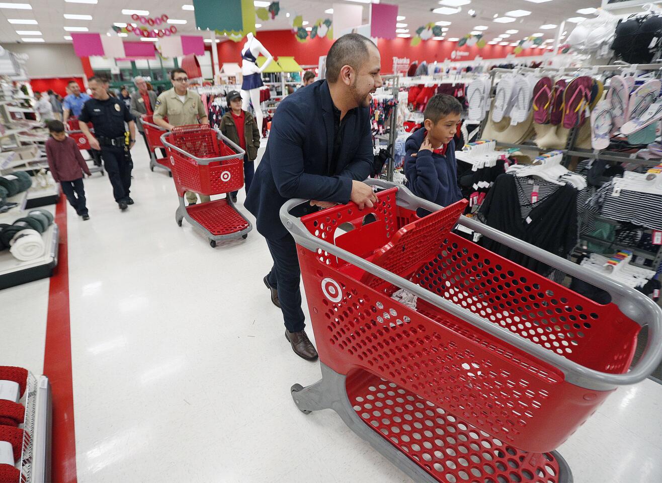 A parade of carts roll out for the Burbank Police Department's annual Heroes and Helpers event at the Empire Center Target on Wednesday, December 12, 2018. Thirty children from the local Boys and Girls Club partnered with Burbank Police officers, outfitted with Target gift cards, to Christmas shop at the store.