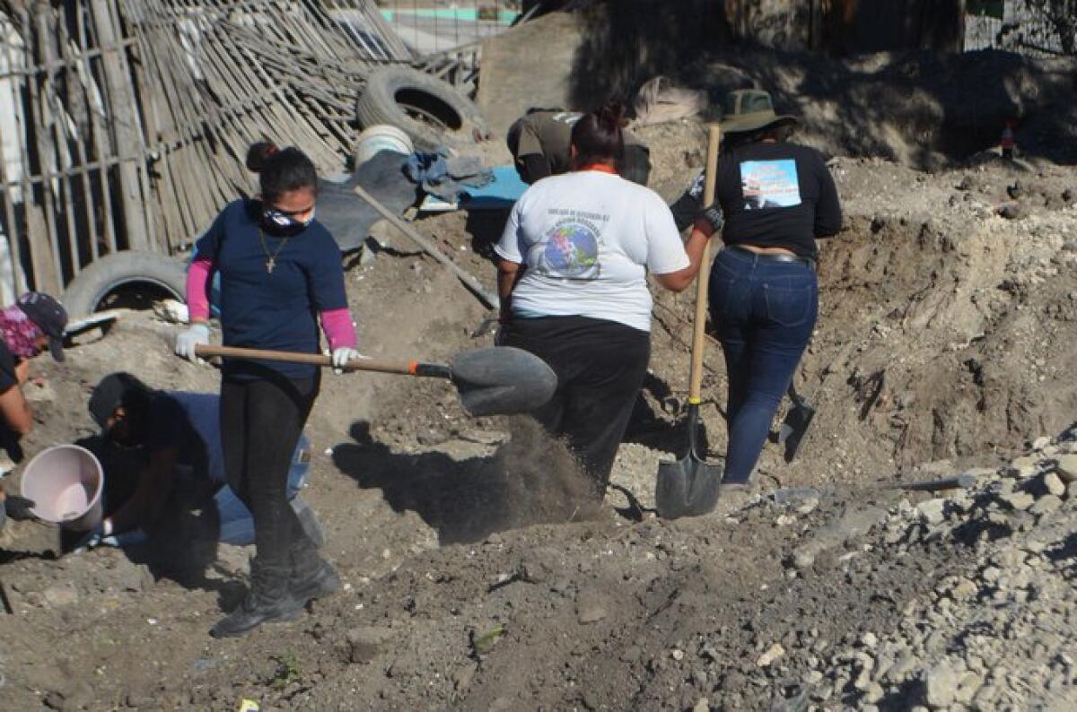 Women dig for human remains on private property in eastern Tijuana on Jan. 16.  