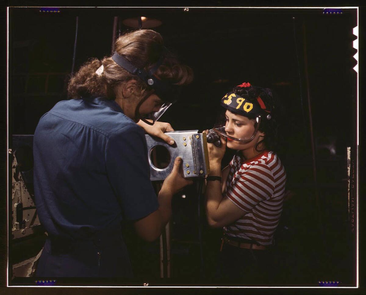 Two female employees of North American Aviation Inc. assembling a section of a wing for a P-51 fighter plane in October 1942.