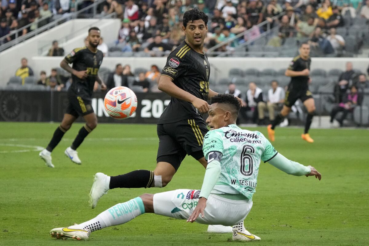 León defender William Tesillo controls the ball in front of LAFC forward Carlos Vela.