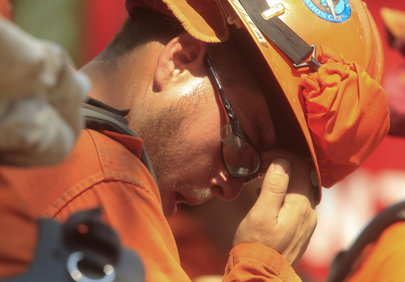 An inmate fire crew member wipes the sweat from his brow as he takes off for the fire line in Silverado Canyon.