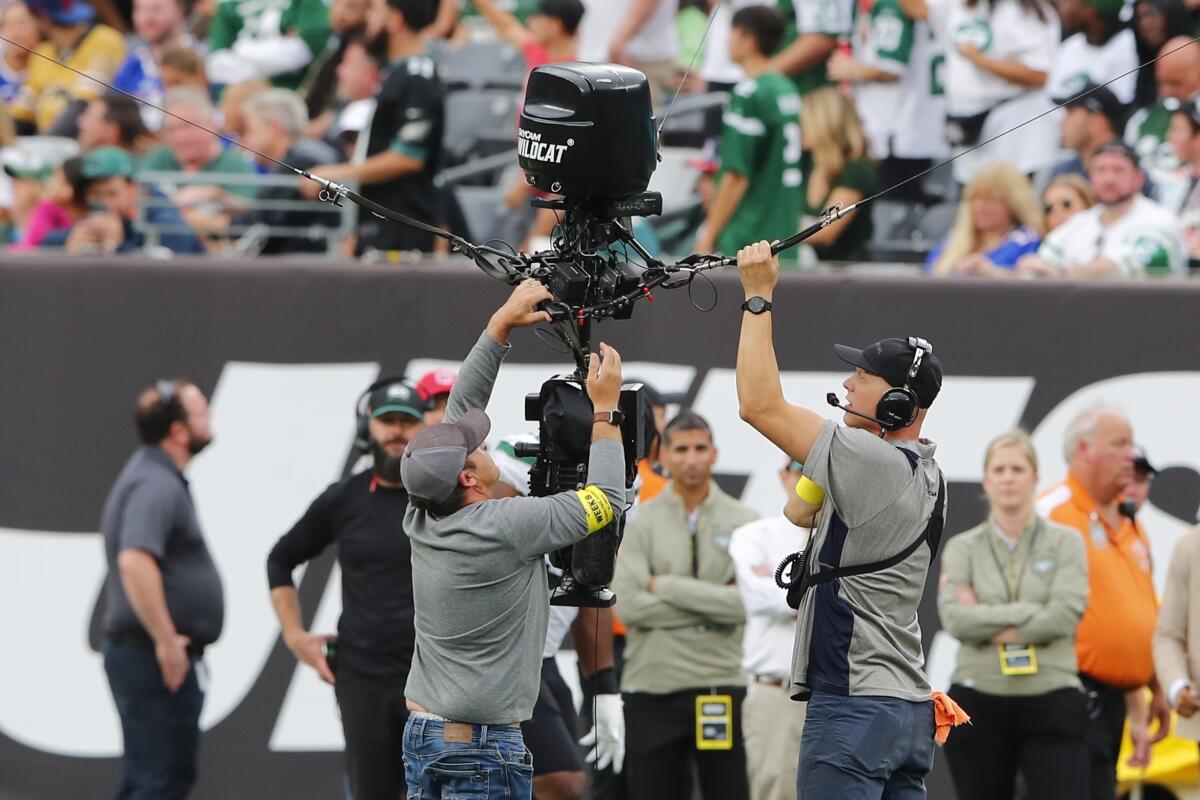 Workers repair a remote camera during a delay during the second half of an NFL football game between the New York Jets and the Buffalo Bills, Sunday, Nov. 6, 2022, in East Rutherford, N.J. (AP Photo/Noah K. Murray)