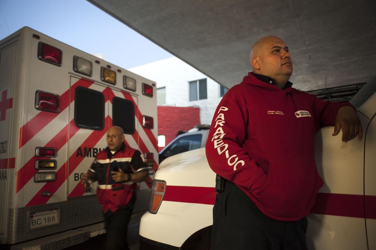 Mexican Red Cross paramedic Daniel Larios waits for a call outside the Red Cross hospital on Friday in Tijuana.