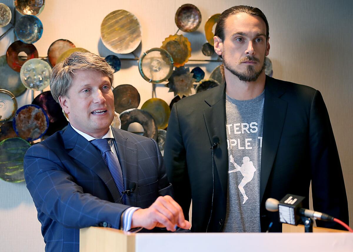 Former Minnesota Vikings punter Chris Kluwe, right, and attorney Clayton Halunen hold a news conference in Minneapolis.