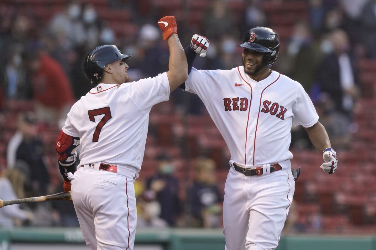 Boston Red Sox's Xander Bogaerts, right, is welcomed home by Christian Vazquez, left, after hitting a two-run home run in the first inning of a baseball game against the Oakland Athletics, Thursday, May 13, 2021, in Boston. (AP Photo/Steven Senne)