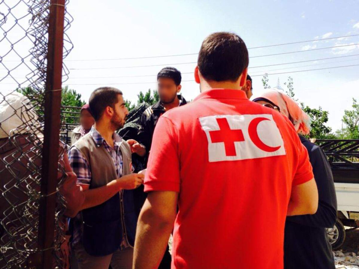 Tareq Alaows stands with Syrian Red Crescent workers 