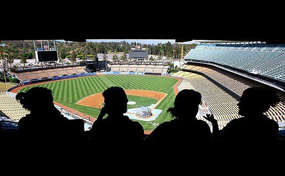 Dodger Stadium employees keep cool in a shaded area before a game against the Houston Astros.