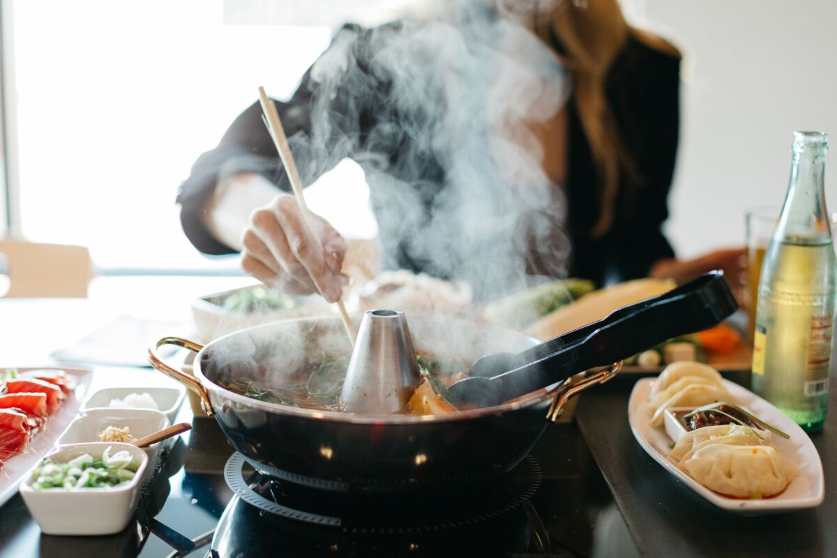 People cook their own food at Tabu Shabu restaurant in Carlsbad