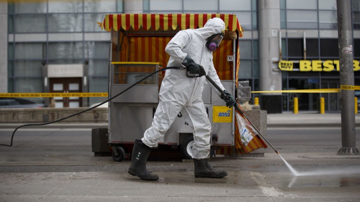 A hazmat worker scrubs the sidewalk of blood and debris after a mass killing in Toronto on April 24. Police arrested a man believed to be part of the radical "incel" community.