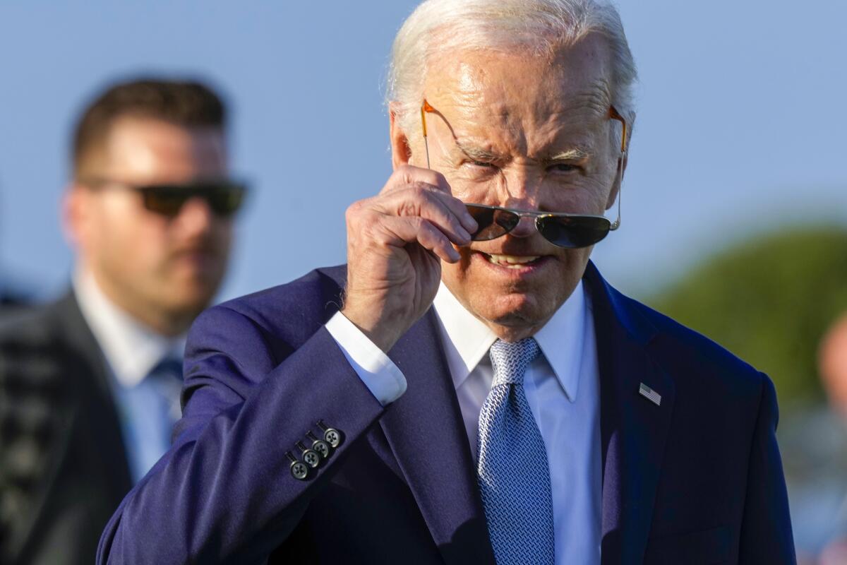El presidente estadounidense Joe Biden se pone las gafas de sol durante un evento 
