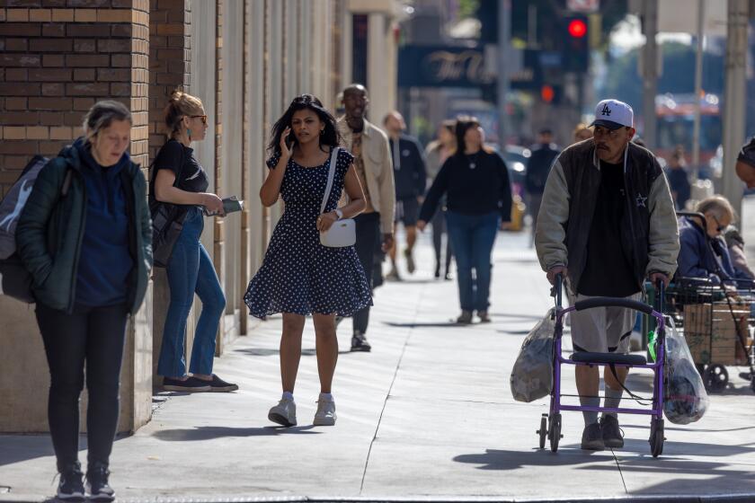 LOS ANGELES, CA - FEBRUARY 13: Pedestrians on 7th. Street in business district of downtown Los Angeles, CA. (Irfan Khan / Los Angeles Times)