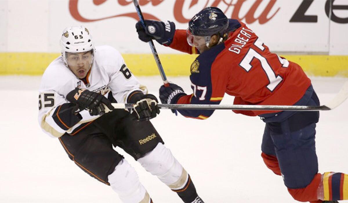 Ducks right wing Emerson Etem, left, and the Panthers' Tom Gilbert, right, chase a loose puck during the Florida's 3-2 win over Anaheim on Tuesday.