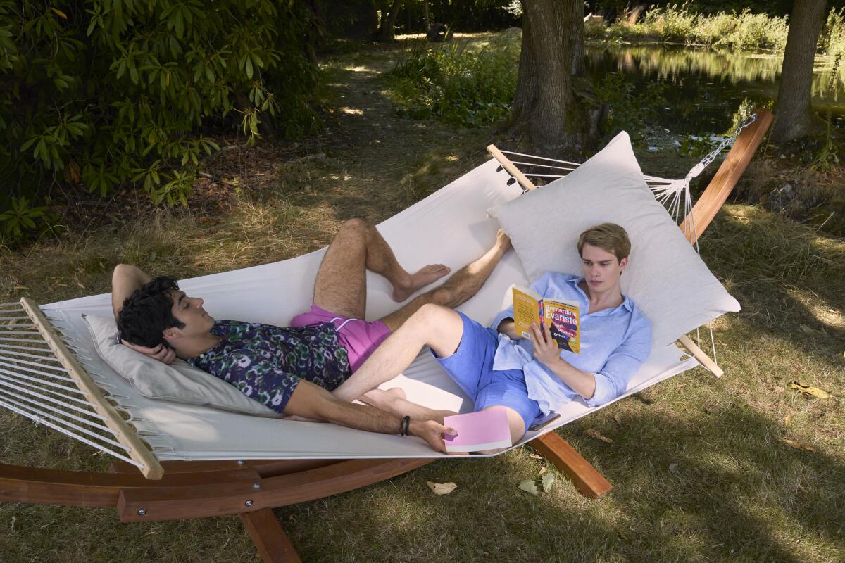 Two men reading in a hammock together