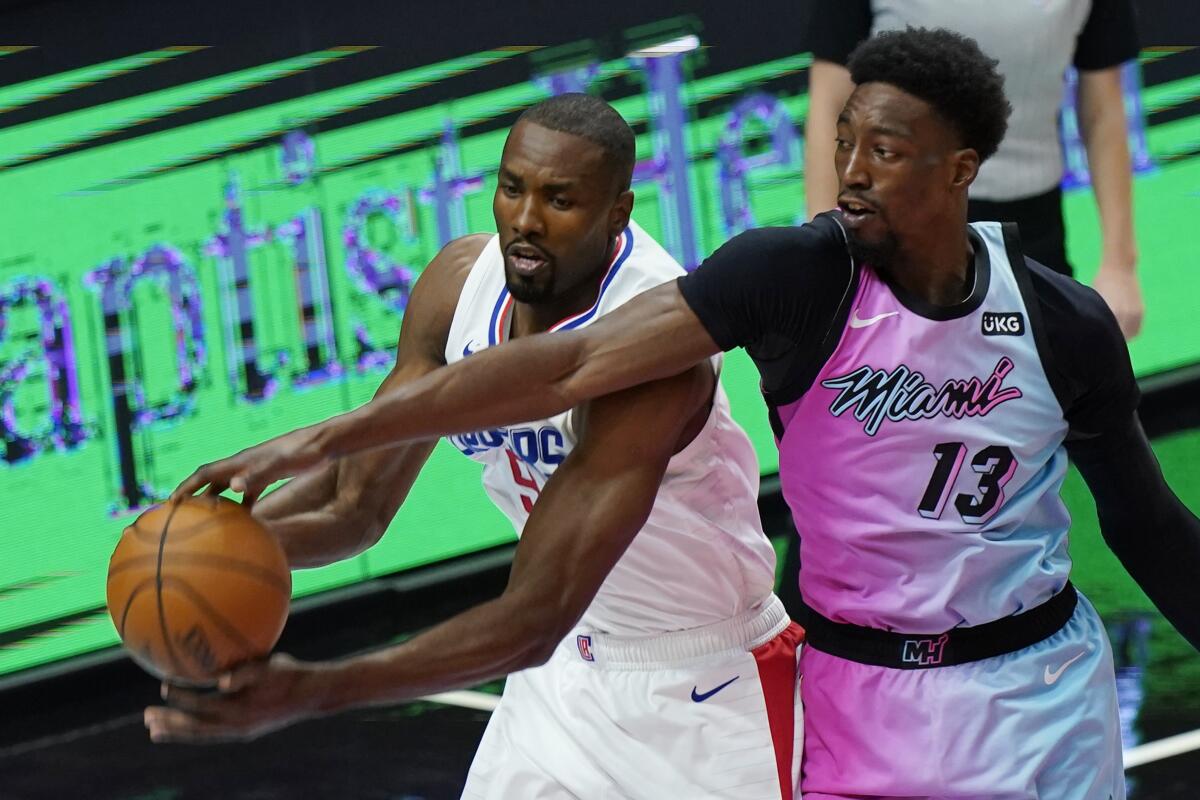 Miami Heat center Bam Adebayo and Clippers center Serge Ibaka go after a rebound.
